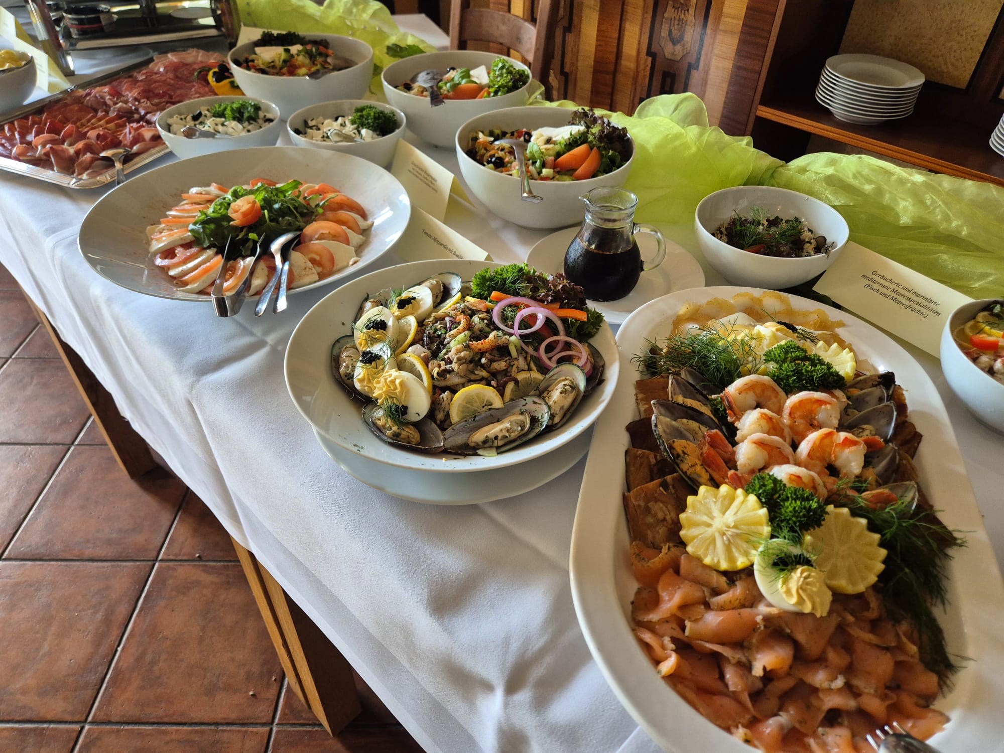 Buffet mit Meeresfruechten und Salaten in Weiss und Gruen, appetitlich dekoriert