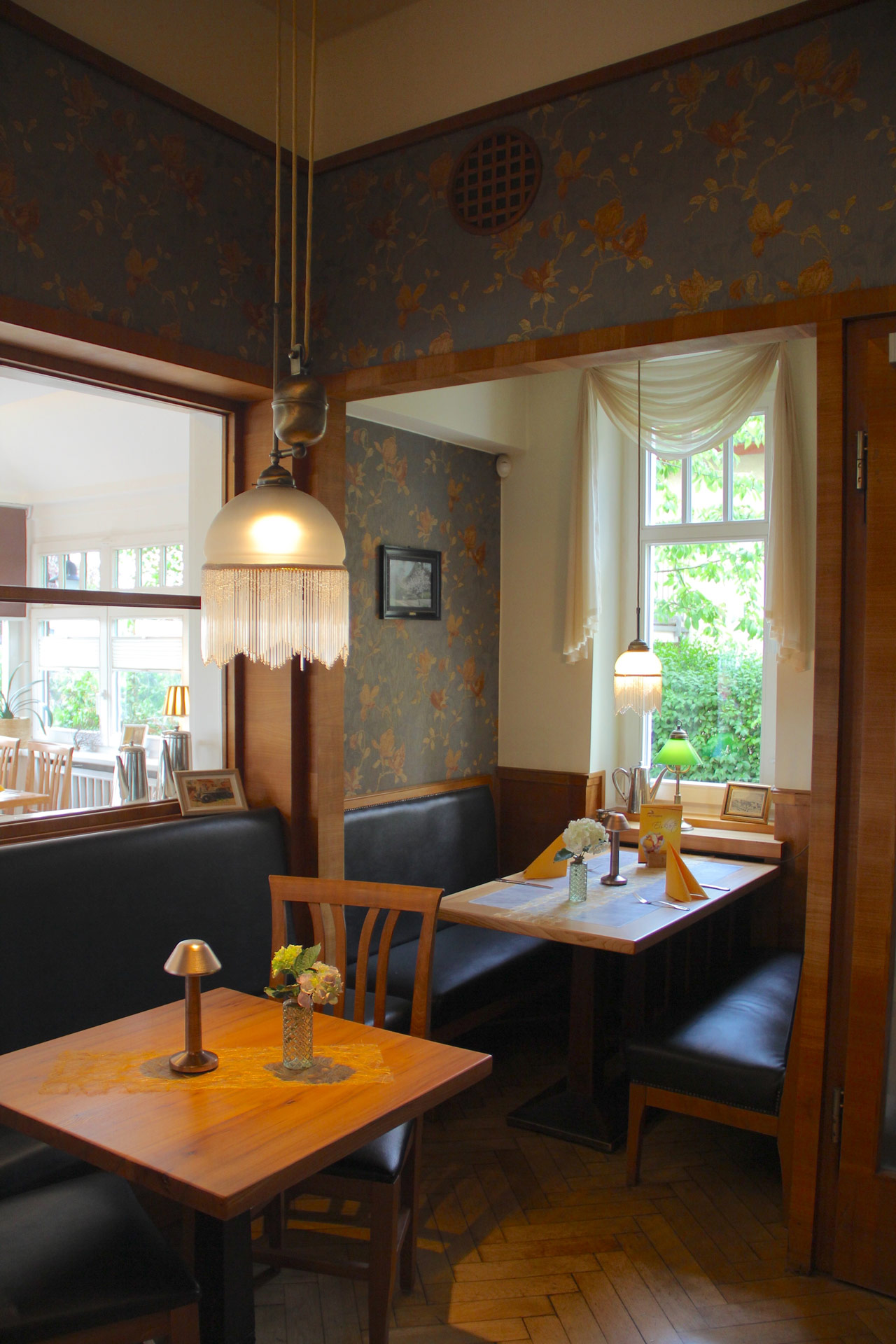Leerer Gastraum mit blauen Polsterbaenken und warmen Holzdetails, Lampen