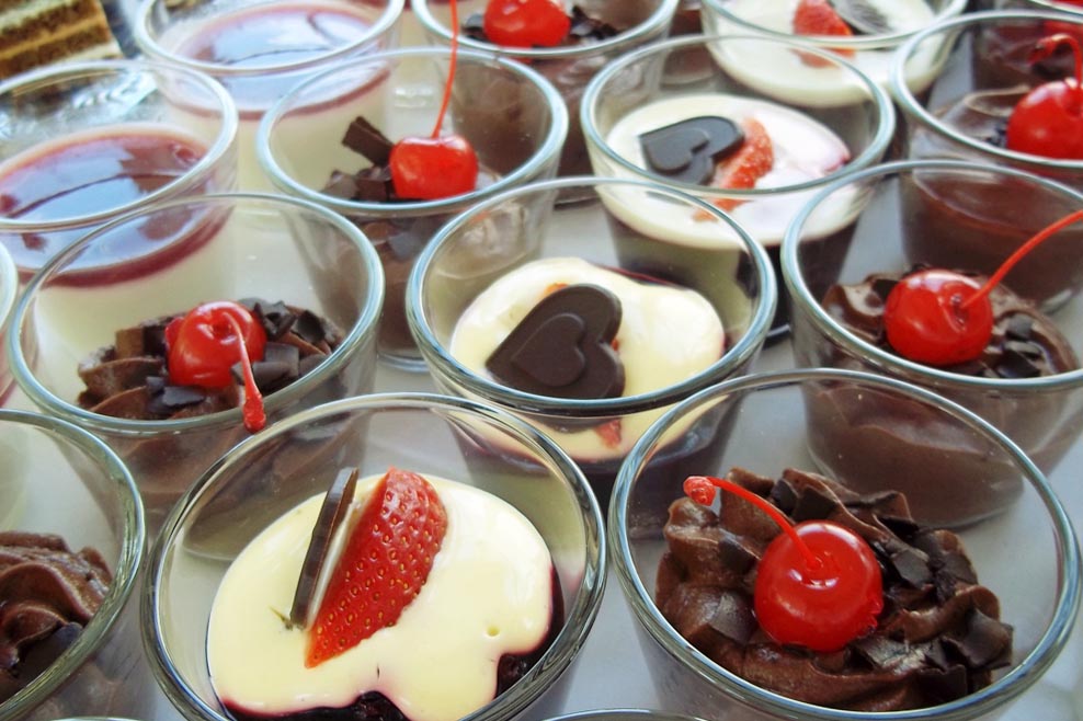 Dessertglaeser mit Schokocreme, Vanillepudding, Erdbeeren und Kirschen