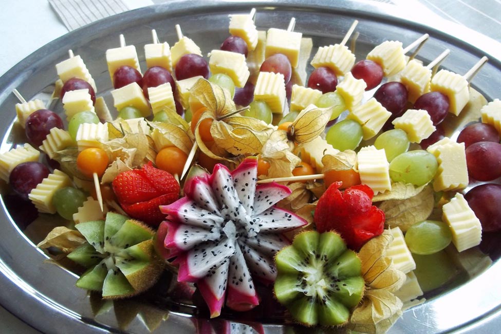 Buntes Obst Kaese Tablett ohne Gesicht mit Trauben Kiwi Drachenfrucht Blume
