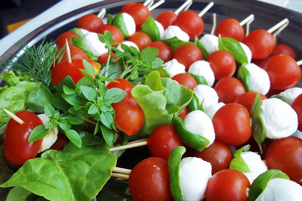Caprese Spieße mit roten Tomaten weißen Mozzarella und grünem Basilikum