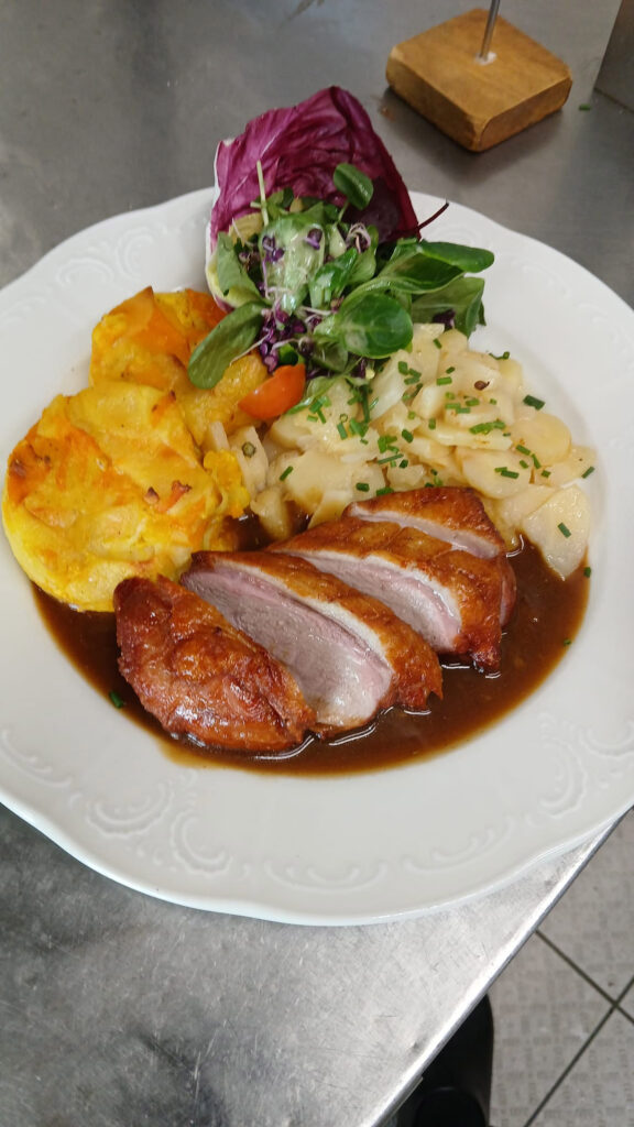 Knusprige Entenbrust in Bratensauce mit Kartoffelgratin und Salat mit Blüten