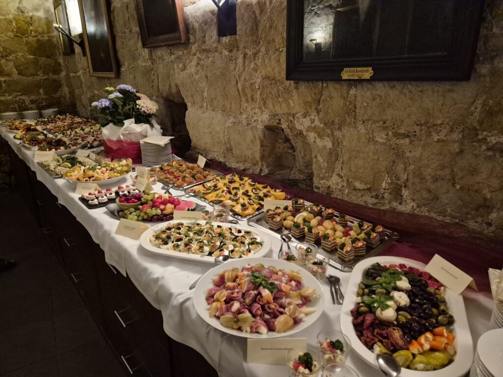 Buffet mit bunten Häppchen und Salaten auf weißer Tafel im Steingewölbe